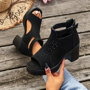 Close-up of black block heel sandals with laser-cut floral details and back zipper