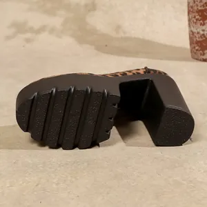 Detailopname van een luipaard platform schoen met een dikke zool en diep loopvlak