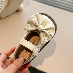Elegant girls' cream Mary Jane shoes featuring a large floral bow and quilted texture