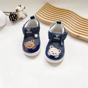 Detailansicht von Baby-Lauflernschuhen mit Bären-Stickerei und weicher Sohle aus Denim