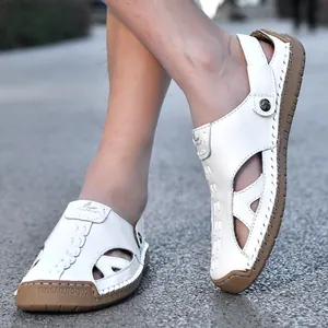 Weiße Herren Outdoor-Sandalen aus Leder mit Lochmuster, auf Asphaltweg getragen.