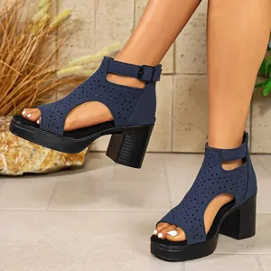 Detailed side view of navy blue chunky high heel sandals featuring elegant laser-cut floral patterns