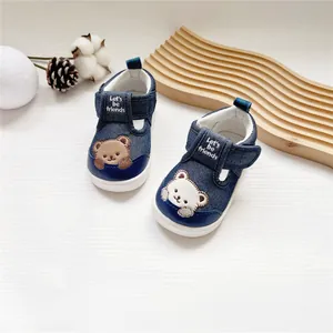 Detailansicht von Denim-Babyschuhen mit süßer Bärenstickerei und praktischem Klettverschluss.