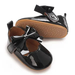 Vue détaillée de chaussures pour bébé fille en cuir verni noir avec un joli nœud et velcro
