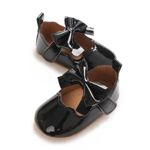 Vue détaillée de chaussures de princesse bébé en cuir verni noir avec un grand nœud mignon