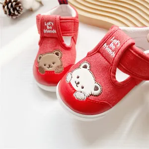 Nahaufnahme roter Baby-Lauflernschuhe mit süßer Bärenstickerei und Klettverschluss