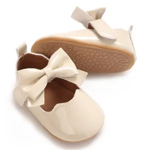 Détail des chaussures en cuir verni beige pour bébé fille avec nœud et bande auto-agrippante