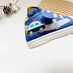 Nahaufnahme eines Cartoon-Polizeiauto-Musters auf blauen weichen Baby-Lauflernschuhen