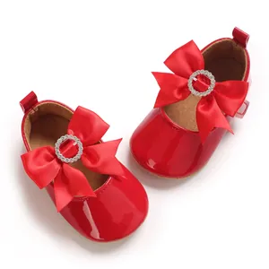 Detailansicht der roten Baby Mary Janes mit eleganter Schleife und Strass-Schnalle