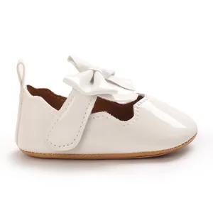 Vue détaillée d'une chaussure bébé fille en cuir vernis blanc avec nœud