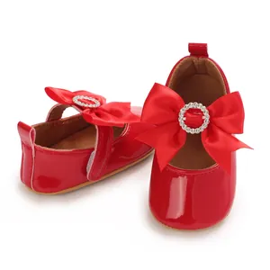 Detailansicht der roten Baby-Lackschuhe mit dekorativer Schleife und Strass-Schnalle