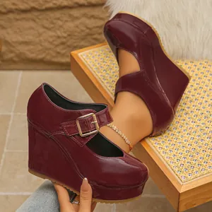 Close-up detail view of burgundy patent leather wedge Mary Jane shoes with thick platform