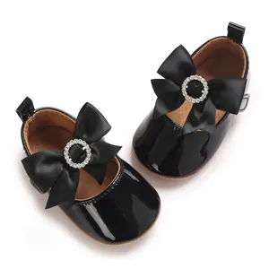 Draufsicht auf schwarze Baby-Lackleder-Schuhe mit dekorativer Schleife und Strass