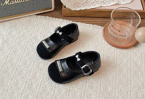Detailansicht der zweifarbigen Mädchen-Mary-Janes in Schwarz mit Metallschleifen