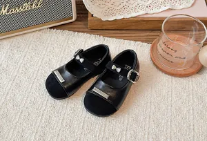 Nahaufnahme von schwarzen Mary Jane-Schuhen für Mädchen mit Schleife und Metallakzenten