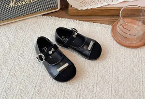 Detailansicht schwarzer Mary Jane Schuhe für Mädchen mit silberner Schleife und Schnalle.