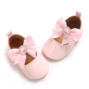 Detailansicht rosa Baby-Lauflernschuhe aus Lackleder mit großer Schleife und Strass