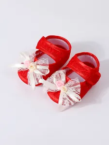 Detailed view of red baby girl princess shoes featuring a delicate lace bow and roses