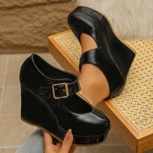 Close-up of black patent leather Mary Jane wedge heels with square toe and buckle detail