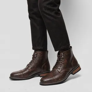 Primo piano di stivali in pelle marrone da uomo retrò con trama vintage e stringhe