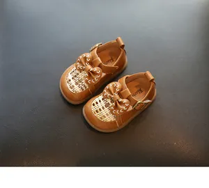 Nahaufnahme brauner Baby-Mädchen-Prinzessin-Schuhe mit Schleife und gewebtem Detail