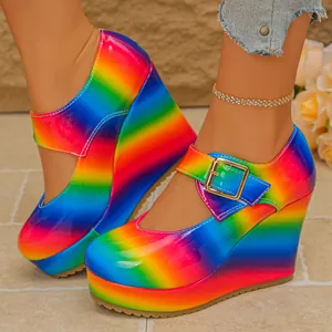 Macro view of vibrant rainbow gradient patent leather Mary Jane wedge platform shoes.