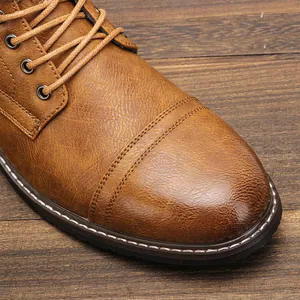 Primo piano di scarponi da lavoro vintage in pelle marrone con texture e lacci dettagliati