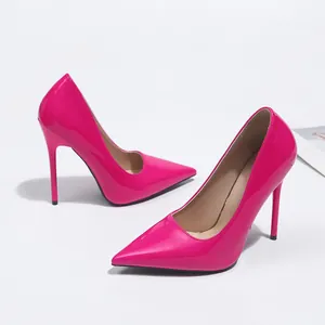Gros plan d'escarpins fuchsia élégants en cuir verni à bout pointu et talons aiguilles