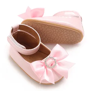Vue détaillée des chaussures de marche rose pour bébé fille avec un nœud en satin