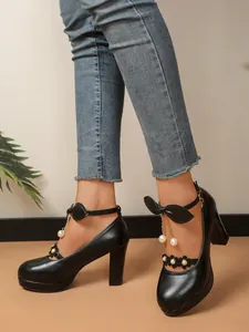 Détail de chaussures Mary Jane noires à talons hauts avec nœuds et perles