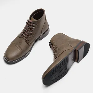 Dettaglio degli stivali da lavoro vintage in pelle marrone per uomo con suole in gomma