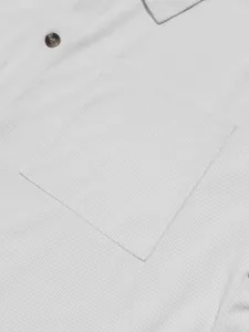 Macro detail of white men's corduroy casual shirt showing pocket and button texture
