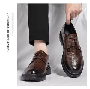 Makroansicht brauner strukturierter Herren-Lederschuhe mit lasergeschnittenen Details