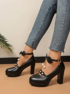 Vue détaillée d'escarpins noirs à talons blocs avec perles et brides à nœuds