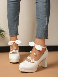 Gros plan de chaussures de princesse blanches avec talons blocs et décor floral