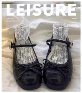 Detailopname van zwarte Franse Mary Jane schoenen voor meisjes met strik en kanten sokken