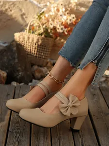 Primer plano de zapatos de tacón Mary Jane beige con elegante lazo y tacón de bloque