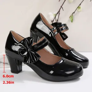 Détail de chaussures Mary Jane vernies noires avec talon épais de 6 cm et nœud