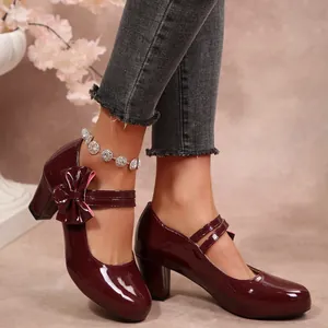 Gros plan sur des escarpins Mary Jane en cuir verni bordeaux avec nœud et talons