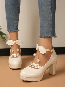 Gros plan sur des escarpins princesse crème à talons épais avec perles