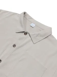 Close-up detail of a beige corduroy shirt for men showing the collar and texture