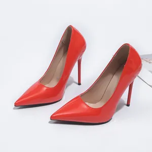 Gros plan détaillé d'escarpins à talons aiguilles en cuir verni rouge brillant.