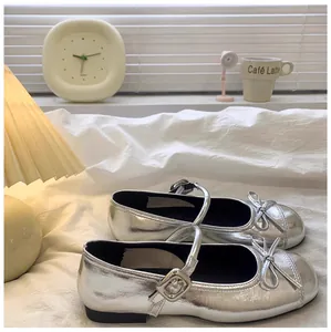 Gedetailleerde weergave van zilveren Mary Jane schoenen voor meisjes met een strikje.