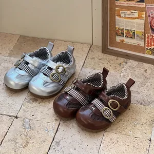 Detail of breathable mesh toddler shoes in silver and brown with retro buckle straps.