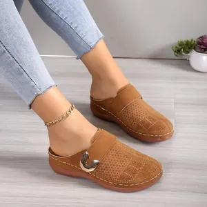 Women's tan platform mules with perforated pattern and metal buckle shown on-feet