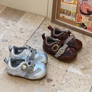 Pair of silver and brown breathable baby mesh walking shoes shown on a stone floor