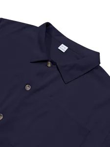 Macro detail of navy blue corduroy shirt showing lapel collar, buttons and size M label.