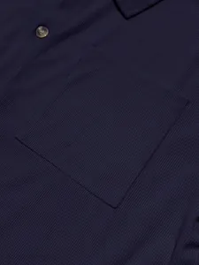Macro view of navy blue corduroy fabric texture showing pocket and button details