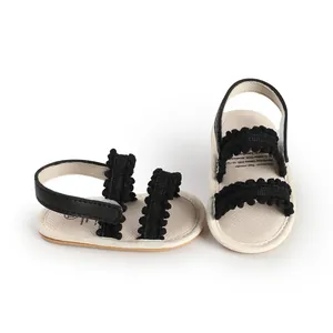 Detailansicht von Baby-Lauflern-Sandalen mit schwarzen Rüschenriemen und beigen Sohlen