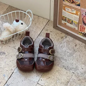 Detailed view of brown baby walking shoes featuring breathable mesh and checkered straps.